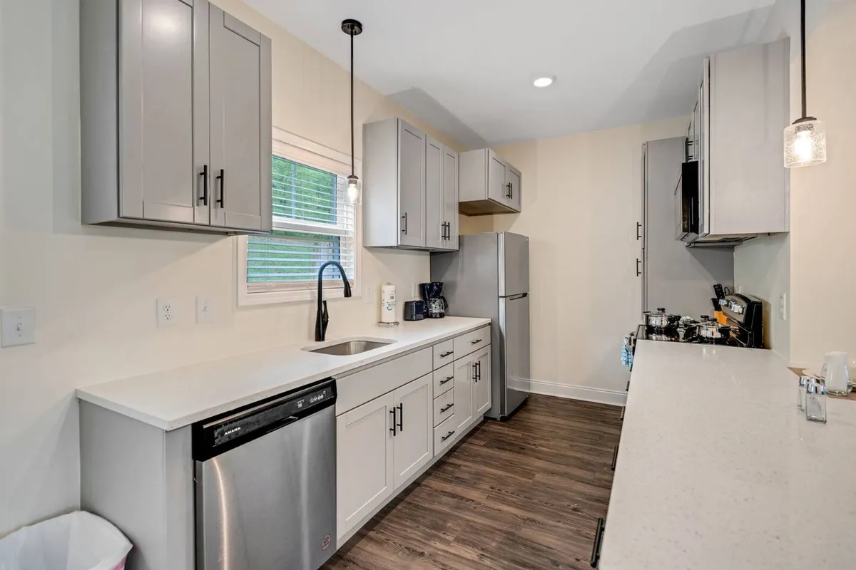 A stylish kitchen setting with modern cabinetry, built-in appliances, and a bright, inviting atmosphere. The well-lit countertops are ideal for meal prep, and the space encourages social interactions—whether preparing a quick coffee or entertaining friends by the kitchen island.